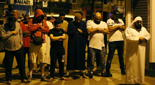 Men pray after a vehicle collided with pedestrians near a mosque in the Finsbury Park neighborhood of North London.