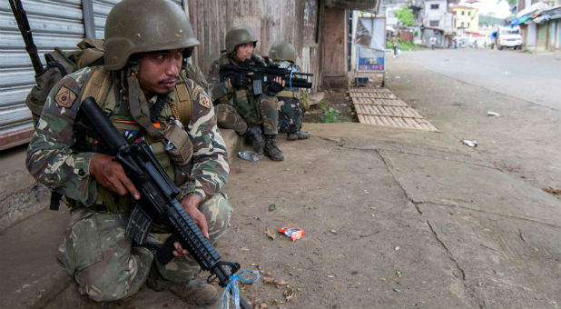 A joint group of police and military forces guard while conducting a house to house search as part of clearing operations in different sections of Marawi city, Philippines.