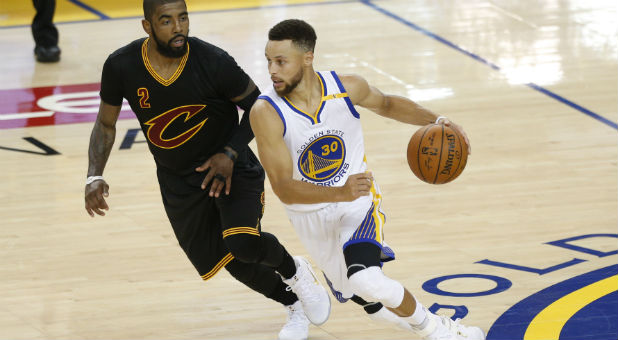 Golden State Warriors guard Stephen Curry (30) dribbles past Cleveland Cavaliers guard Kyrie Irving (2).