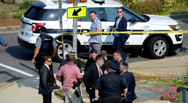 Police and investigators gather at an intersection near the scene where shots were fired during a congressional baseball practice, wounding House Majority Whip Steve Scalise.