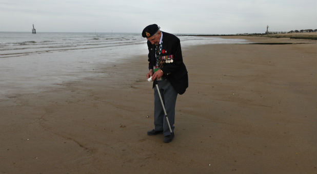 D-Day veteran Joseph Cauch of Toronto wraps up an oyster shell he found on the beach at sunset after a Canadian-French ceremony at the Juno Beach Center in Courseulles sur Mer June 6, 2014. World leaders and veterans gathered by the beaches of Normandy on Friday to mark the 70th anniversary of World War Two's D-Day landings.