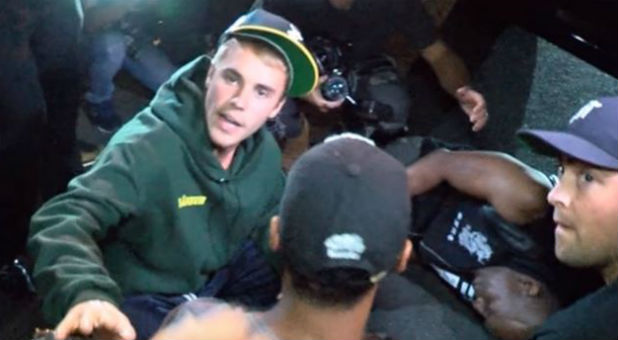 Justin Bieber waits with a photographer after hitting him with his car.