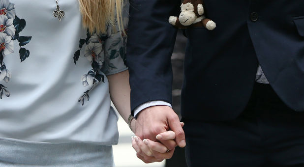 The father of critically ill baby Charlie Gard carries a toy monkey in his pocket as he and Connie Yates, Charlie Gard's mother, arrive at the High Court in London.