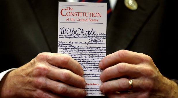 A member of Congress holds a copy of the U.S. Constitution.