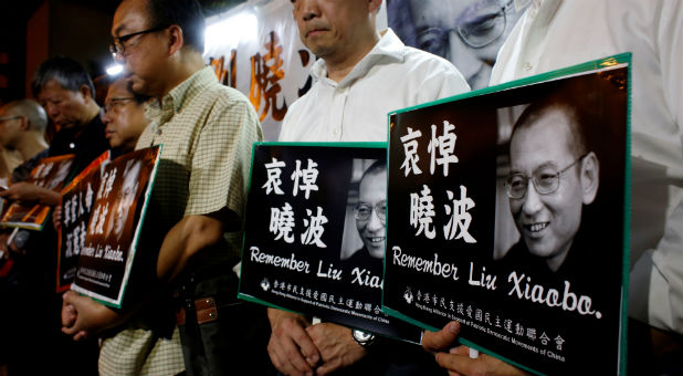 Pro-democracy activists mourn the death of Chinese Nobel Peace laureate Liu Xiaobo, outside China's Liaison Office in Hong Kong, China.