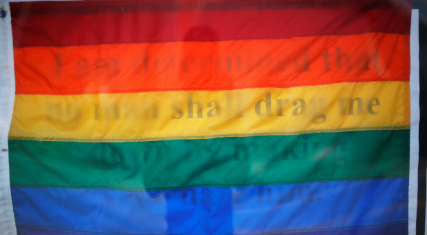 A gay pride flag covers the Booker T. Washington quote,