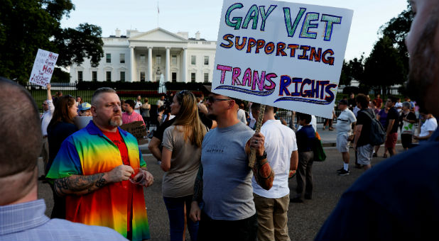Demonstrators gather to protest President Donald Trump's announcement that he plans to reinstate a ban on transgender individuals from serving in any capacity in the U.S. military, at the White House in Washington.