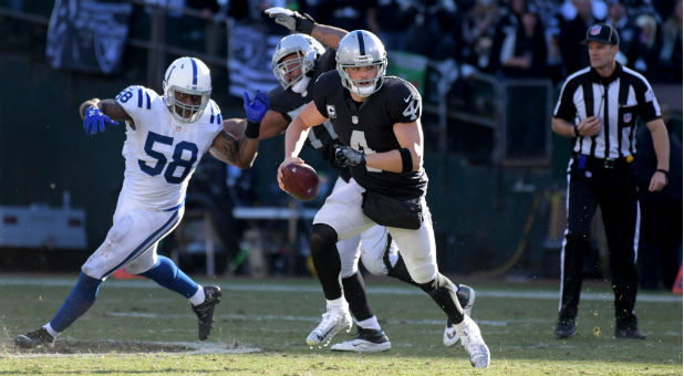 Oakland Raiders quarterback Derek Carr (4) carries the ball in the third quarter against the Indianapolis Colts during a NFL football game at Oakland-Alameda Coliseum.