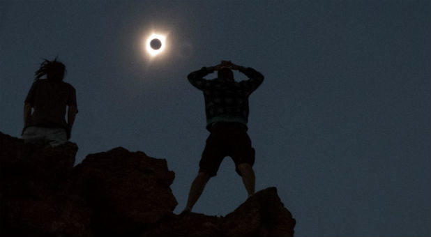 Enthusiasts Tanner Person (R) and Josh Blink, both from Vacaville, California, watch a total solar eclipse while standing atop Carroll Rim Trail at Painted Hills, a unit of the John Day Fossil Beds National Monument, near Mitchell, Oregon, Aug. 21, 2017.