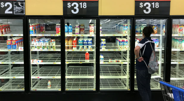 An unidentified woman looks over bare refrigerator shelves in a Walmart store in Houston, Texas, as Hurricane Harvey approaches landfall near the Texas coastal area.