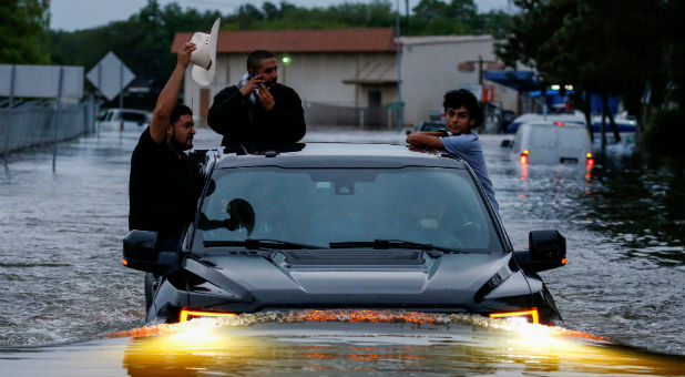 Residents use a truck to navigate through flood waters from Tropical Storm Harvey in Houston, Texas, U.S. Aug. 27, 2017.