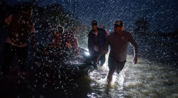 Samaritans help push a boat with evacuees to high ground during a rainstorm caused by Tropical Storm Harvey along Tidwell Road in east Houston, Texas, U.S. August 28, 2017.