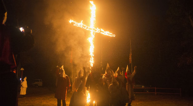 Members of the Rebel Brigade Knights and the Nordic Order Knights, groups that both claim affiliation with the Ku Klux Klan, gather for a group photograph in front of a lit cross after a cross lighting ceremony at a private residence in Henry County, Virginia, Oct.11, 2014.