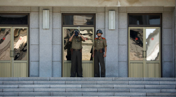 A North Korean soldier keeps watch toward the south through a binocular telescope at the truce village of Panmunjom, South Korea, Aug. 26, 2017.