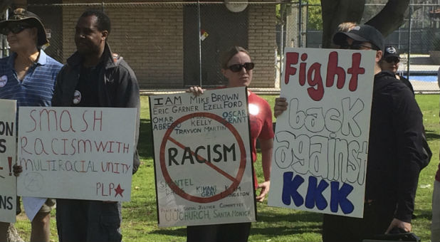 Counter protesters hold placards near a planned Klu Klux Klan rally in Anaheim, California Feb. 27, 2016. At least three people were stabbed on Saturday and one of them was critically wounded in a scuffle between members of the KKK and counter protesters near the planned rally, police said.