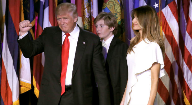U.S. President Donald Trump gestures as the takes the stage with his wife Melania and his son Baron