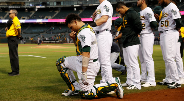 Bruce Maxwell of the Oakland Athletics kneels during the singing of the National Anthem.