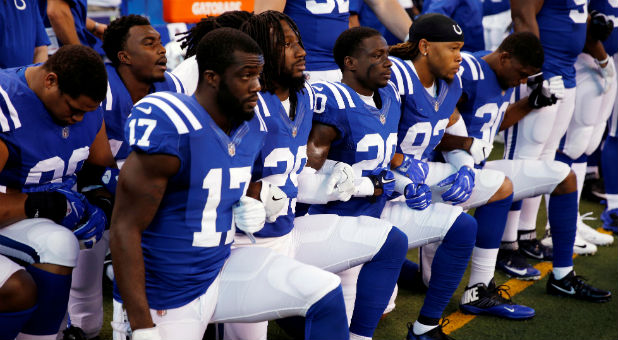Indianapolis Colts players kneel during the playing of the National Anthem.