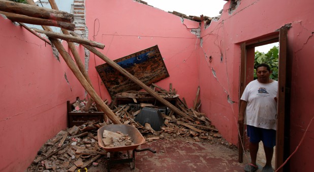 A man stands by his damaged home in Mexico.