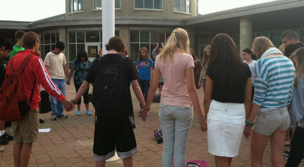 Students gather at the flag pole to pray.