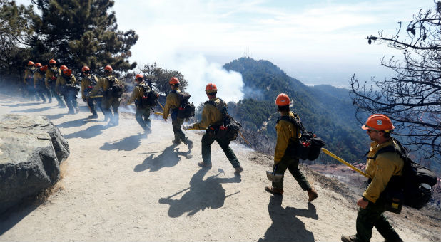 Members of the Los Padres Hot Shot crew walk atop a hill during the Wilson Fire near Mount Wilson in the Angeles National Forest in Los Angeles.