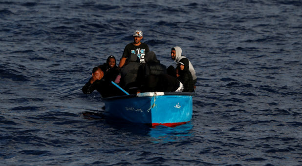 Migrants awaiting rescue on a wooden boat are seen from the migrant search-and-rescue vessel.