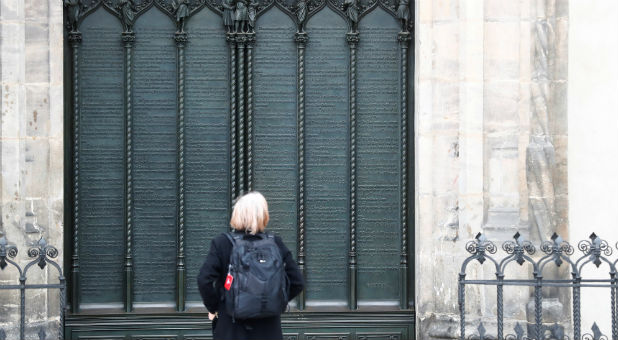 A woman looks at German theologian Martin Luther's theses door during the 500th Anniversary of the Reformation at the Castle Church in Wittenberg, Germany.