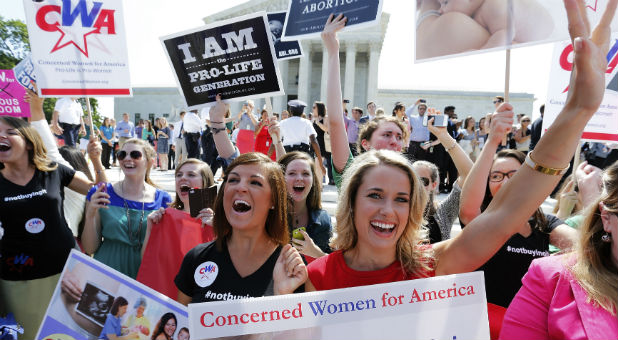 Pro-life demonstrators cheer as the ruling for Hobby Lobby was announced outside the U.S. Supreme Court in Washington June 30, 2014.