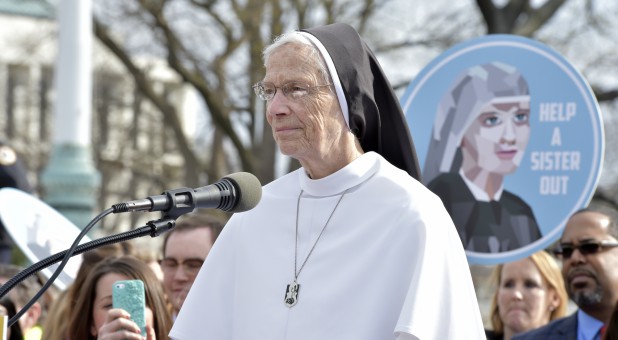 A nun speaks at a rally.