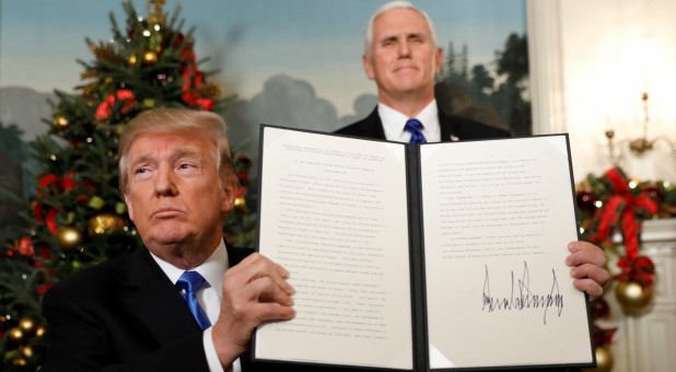 U.S. Vice President Mike Pence stands behind as U.S. President Donald Trump holds up the proclamation he signed that the United States recognizes Jerusalem as the capital of Israel and will move its embassy there.