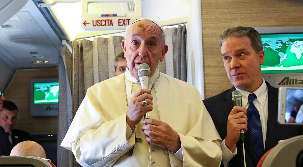 Pope Francis speaks to reporters on board the plane for his trip to Chile and Peru.