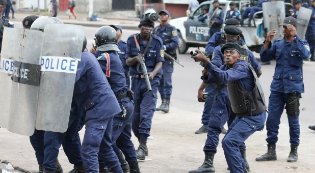 Policemen react after a protester threw a stone from Notre Dame Cathedral compound in Kinshasa, Democratic Republic of Congo.