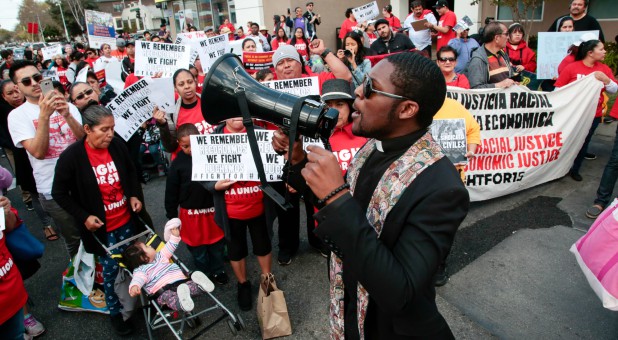 Pastor Eddie Anderson leads a chant with fast-food workers and supporters during a protest outside a McDonald's restaurant in Los Angeles, California.