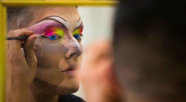 A participant prepares to perform in a drag queen competition during carnival festivities.