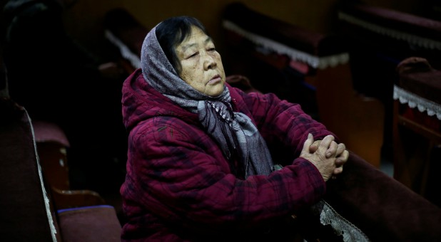 72-year-old villager Zha Shuzhen prays.