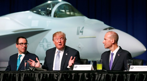 U.S. President Donald Trump sits between Treasury Secretary Steve Mnuchin (L) and Boeing Chairman and CEO Dennis Muilenburg (R)
