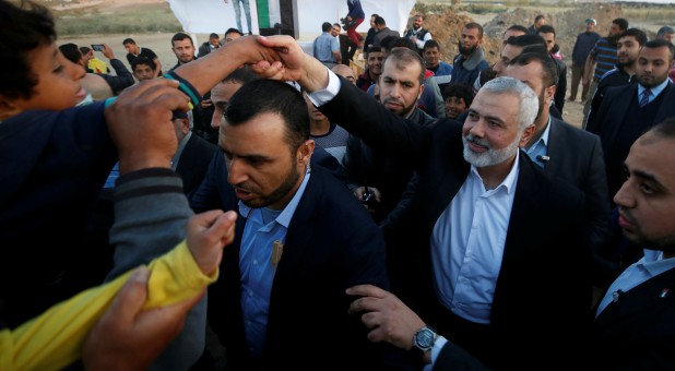 Palestinian Hamas Chief Ismail Haniyeh shakes hands with a boy during a protest demanding the right to return to their homeland, at the Israel-Gaza border, east of Gaza City.