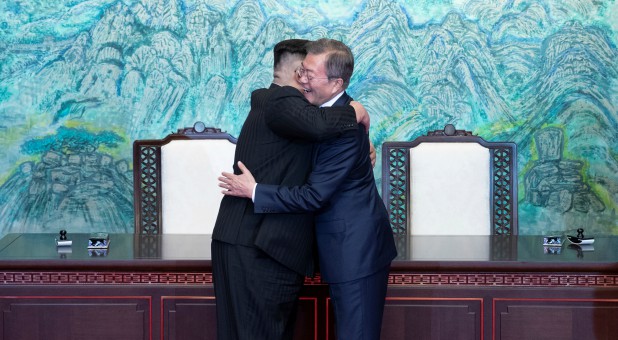 The leaders of North and South Korea hug.