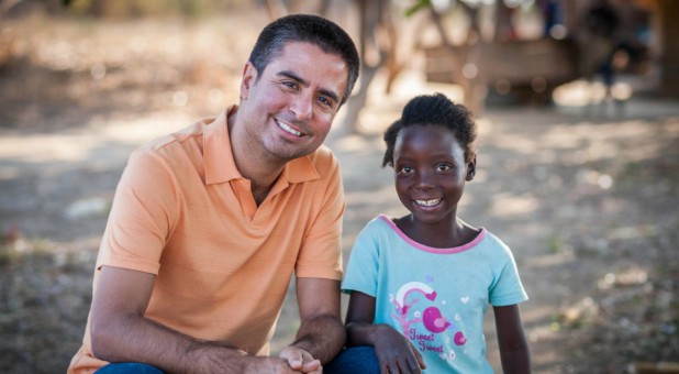 Edgar Sandoval poses with 8-year-old Faith, his World Vision sponsored child, in Kapululwe, Zambia.