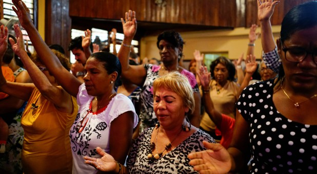 People react during a religious ceremony where victims of the Boeing 737 plane crash were remembered at a church in Havana, Cuba.