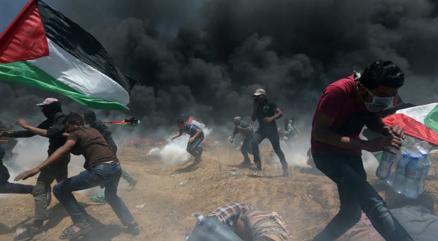 Palestinian demonstrators run for cover from Israeli fire and tear gas during a protest against U.S. Embassy move to Jerusalem.