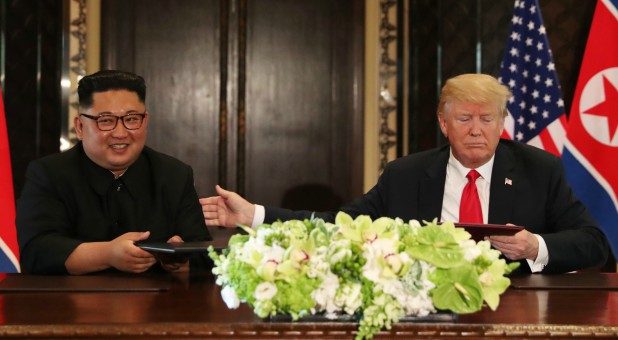 U.S. President Donald Trump and North Korea's leader Kim Jong Un attend a signing ceremony during a summit.