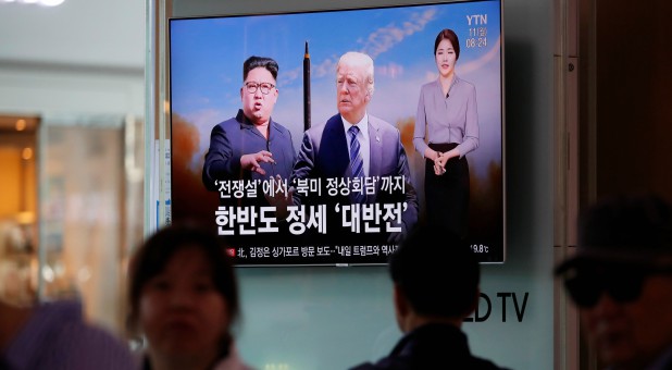 People watch a TV broadcasting a news report on the upcoming summit between the U.S. and North Korea.