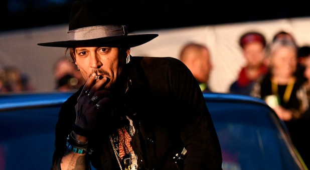 Actor Johnny Depp poses on a Cadillac in June 2017.