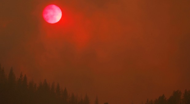 The setting sun is turned red by the smoke from the Carr Fire burning in the hills west of Redding, California.