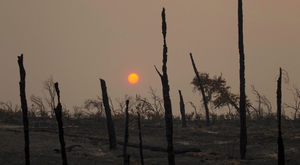 The sun sets over hills burned by the Carr Fire west of Redding, California.