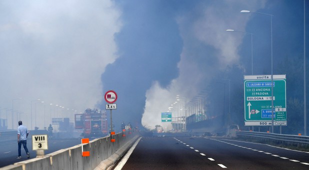 Firefighters work on the motorway after an accident caused a large explosion and fire at Borgo Panigale.