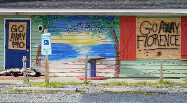 A sign is posted on a boarded-up building before Hurricane Florence comes ashore on Oak Island, North Carolina.