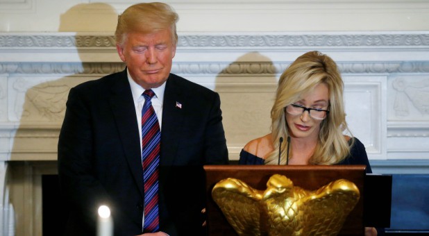 U.S. President Donald Trump closes his eyes as Pastor Paula White leads a prayer.
