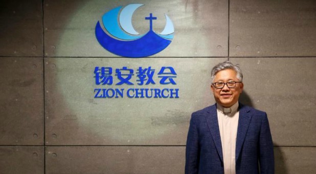 The head pastor of the Zion church in Beijing, Jin Mingri. poses for picures in the lobby of the unofficial Protestant